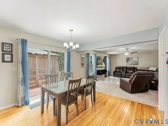a view of a dining room with furniture a chandelier and wooden floor