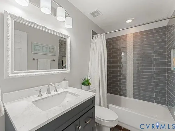 a bathroom with a sink vanity mirror and toilet