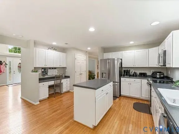 a kitchen with white cabinets and stainless steel appliances