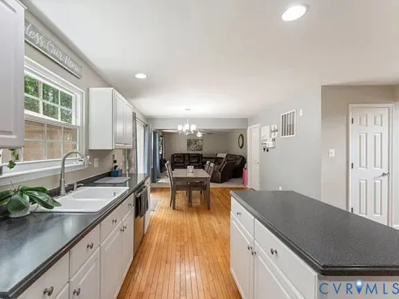 a kitchen with granite countertop a sink stove and cabinets
