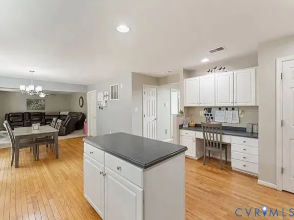 a living room with stainless steel appliances kitchen island a table and chairs in it