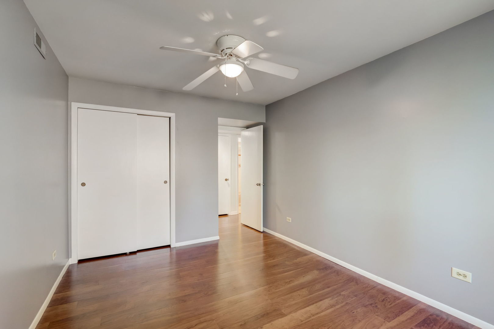 550 East Main Street, Unit 2E Barrington, IL 60010 - Photo 13 of 19 a view of an empty room with wooden floor and a ceiling fan