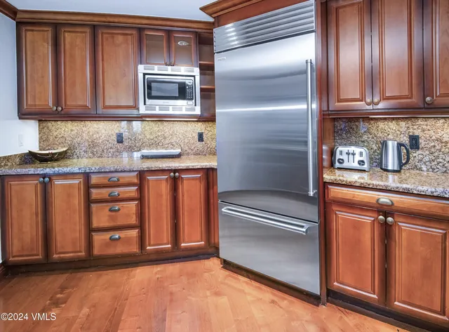 a kitchen with granite countertop stainless steel appliances and cabinets
