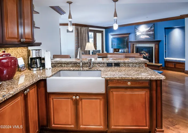 a kitchen with kitchen island granite countertop wooden cabinets a sink and dishwasher