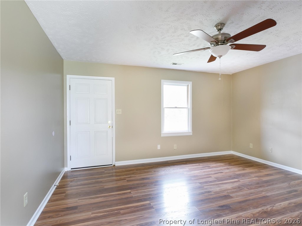 115 Eulon Loop, Unit A Raeford, NC 28376 - Photo 4 of 16 an empty room with wooden floor fan and windows
