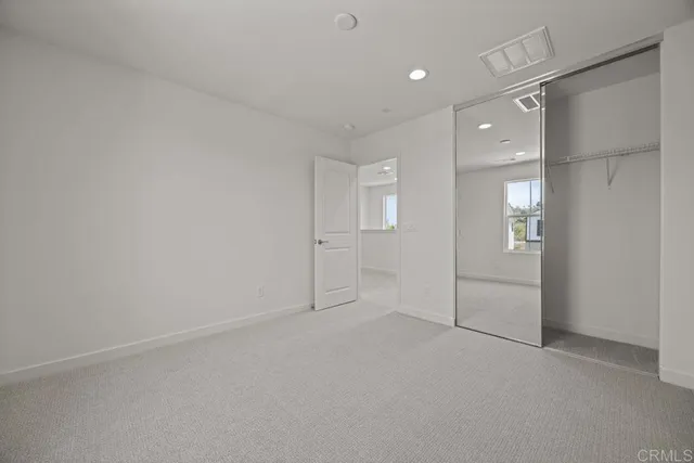 an empty room with entrance and mirror