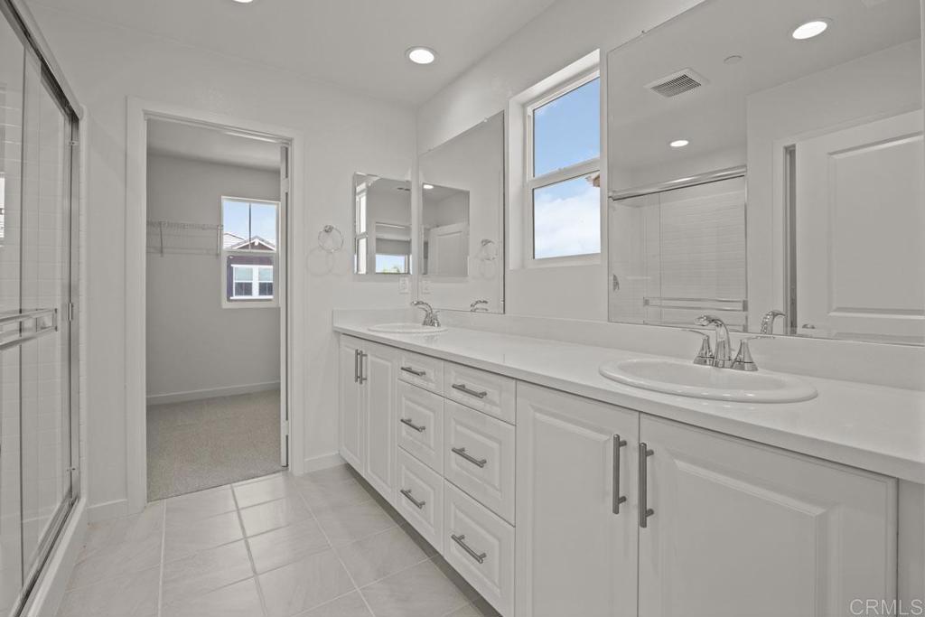 740 Kingbird Loop Oceanside, CA 92058 - Photo 16 of 23 a bathroom with double sink and a mirror