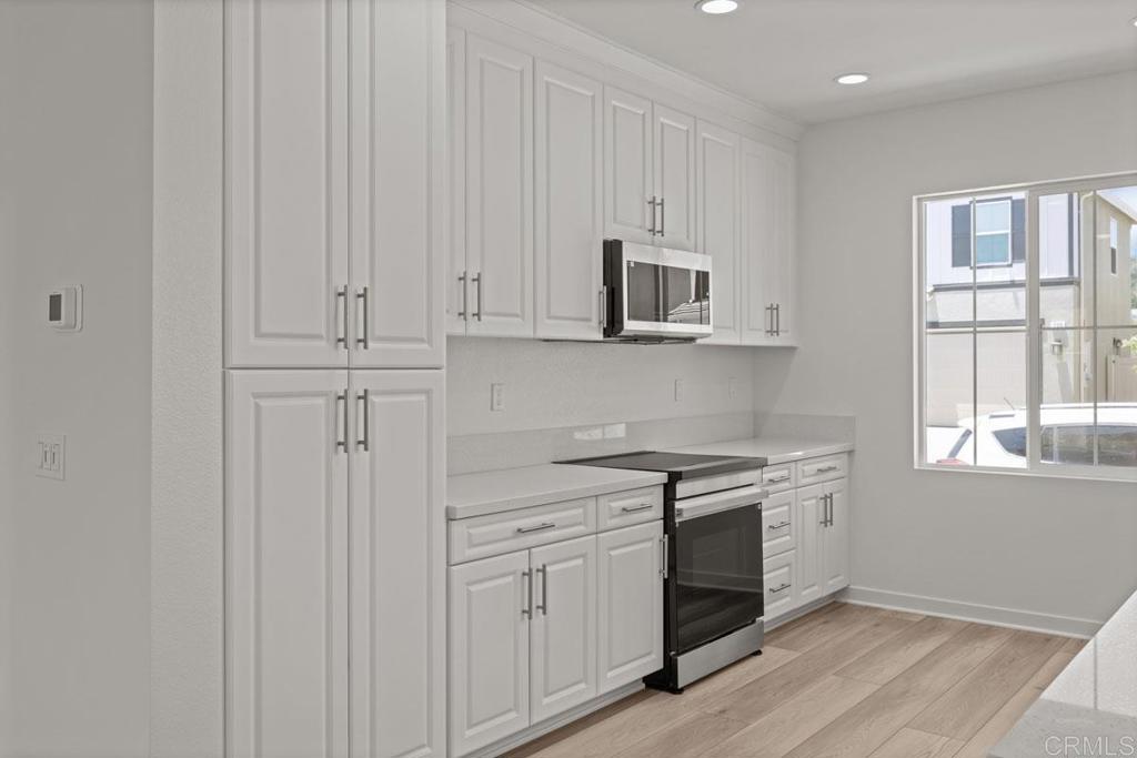 740 Kingbird Loop Oceanside, CA 92058 - Photo 19 of 23 a kitchen with stainless steel appliances granite countertop white cabinets and window