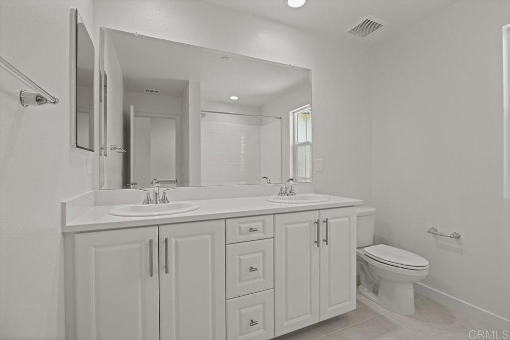 740 Kingbird Loop Oceanside, CA 92058 - Photo 9 of 23 a bathroom with a toilet sink and mirror