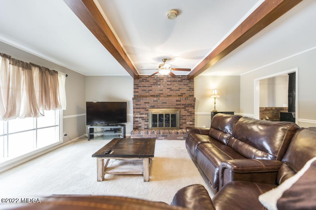 694 Moncrief Road Roberta, GA 31078 - Photo 15 of 45 a living room with furniture a fireplace and a flat screen tv