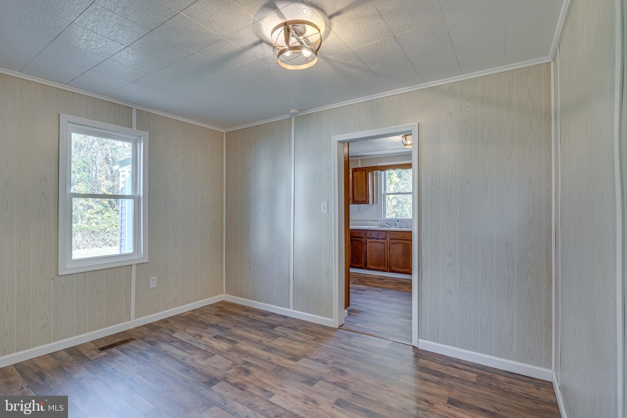 56 Clems Drive Ranson, WV 25438 - Photo 5 of 25 a view of an empty room with a window and wooden floor