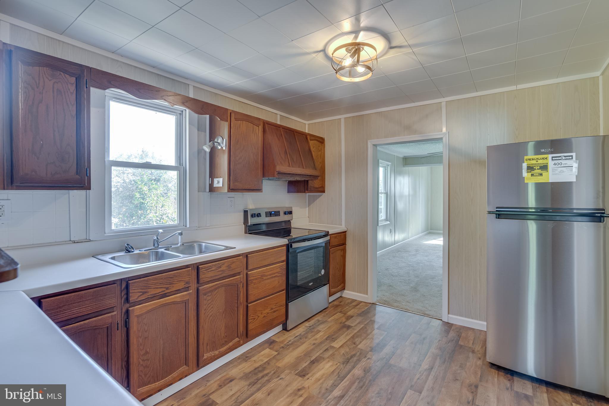 56 Clems Drive Ranson, WV 25438 - Photo 9 of 25 a kitchen with a sink cabinets a window and stainless steel appliances