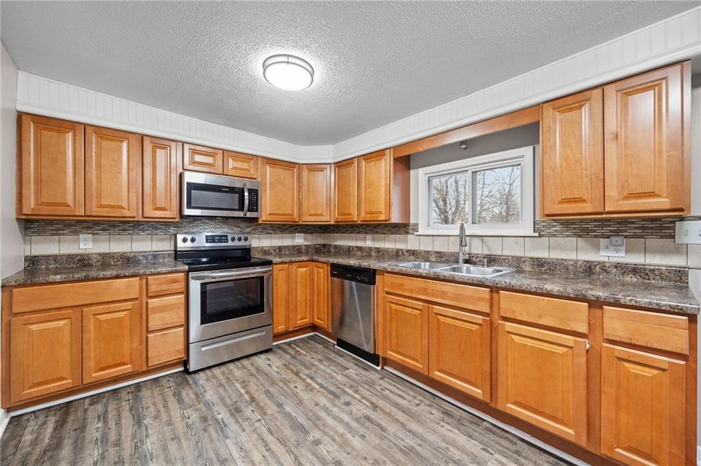145 Lawrence Avenue Washington, PA 15301 - Photo 6 of 32 a kitchen with granite countertop wooden cabinets stainless steel appliances a sink and a window
