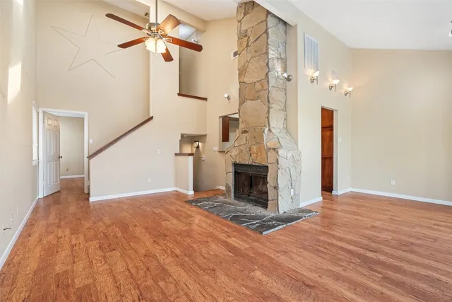a view of a livingroom with wooden floor and a ceiling fan