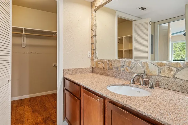 a bathroom with a granite countertop sink and a mirror