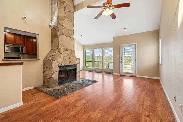 a view of empty room with fireplace and wooden floor