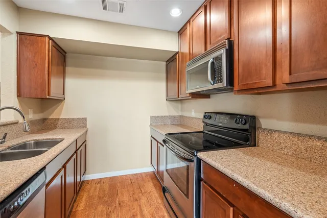 a kitchen with stainless steel appliances granite countertop a sink stove and microwave