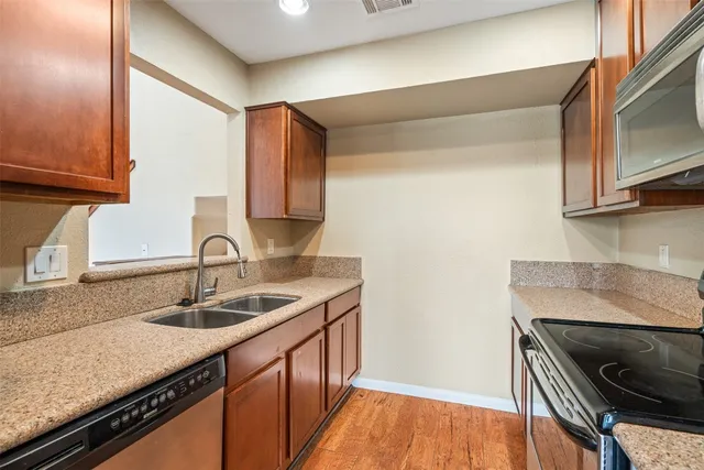 a kitchen with granite countertop a sink a stove and cabinets