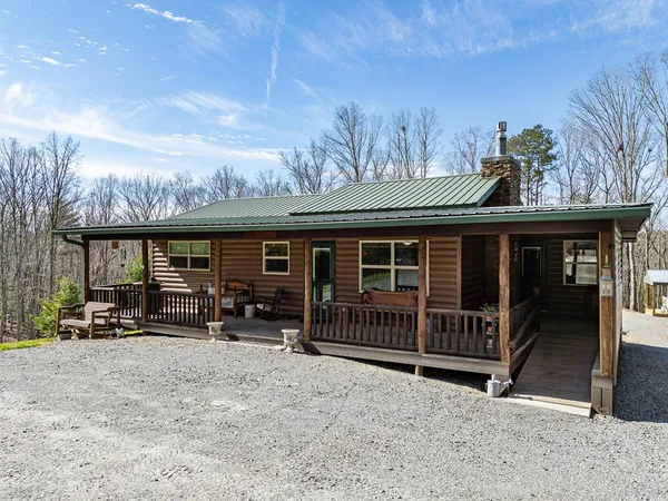 a backyard of a house with wooden floor a fire pit and furniture