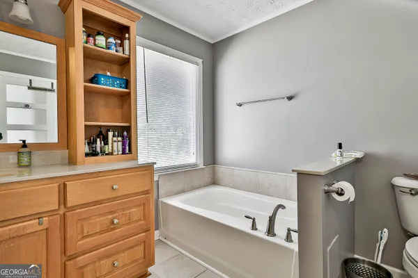a bathroom with a tub sink and mirror