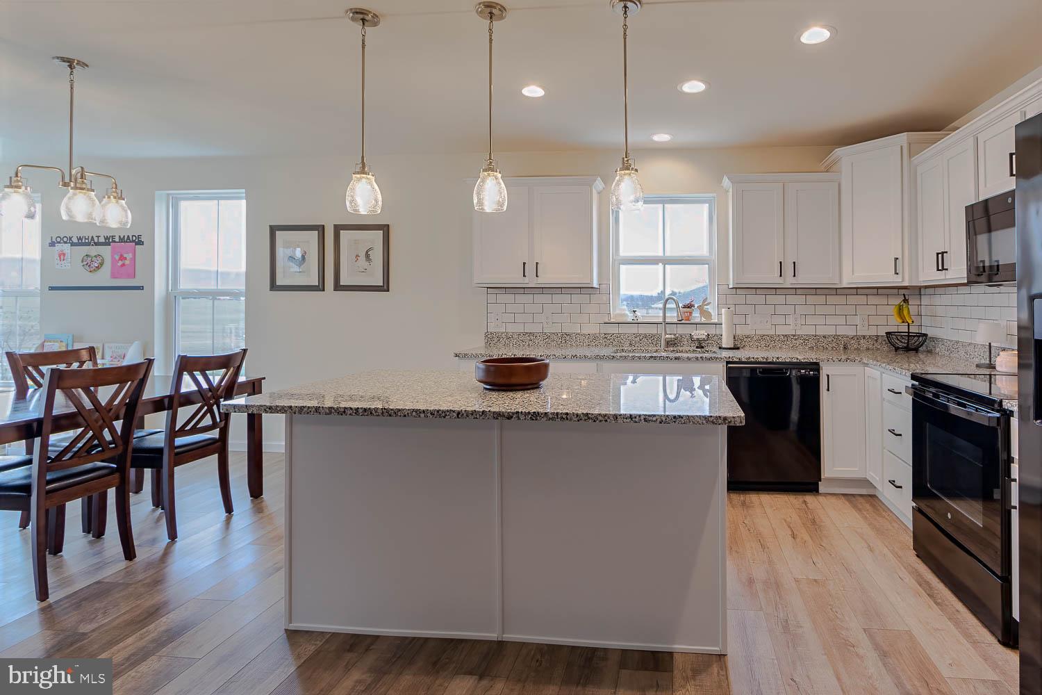 204 Whitetail Circle Mill Hall, PA 17751 - Photo 10 of 33 a kitchen with stainless steel appliances kitchen island granite countertop a stove a sink a window and white cabinets