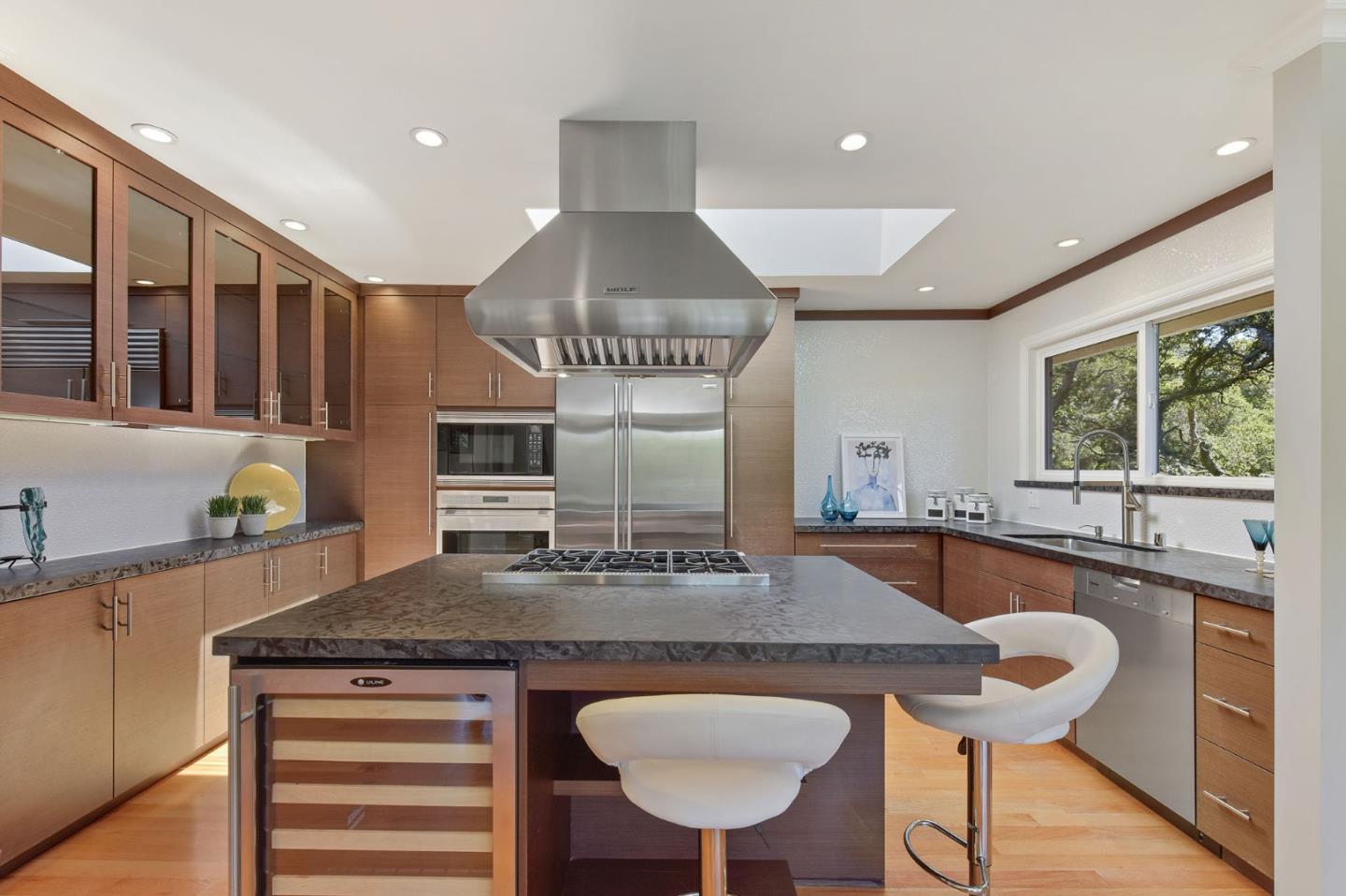 39 Colorados Drive Millbrae, CA 94030 - Photo 10 of 49 a kitchen with kitchen island granite countertop a stove a sink a dining table and chairs