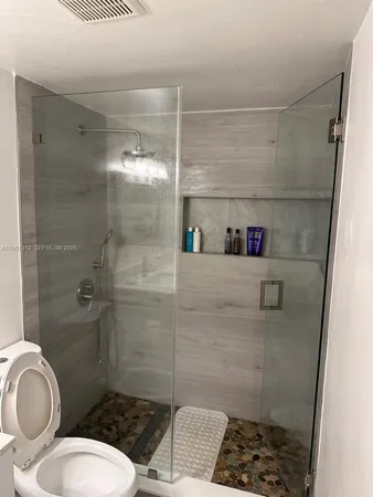 a bathroom with a toilet and a shower