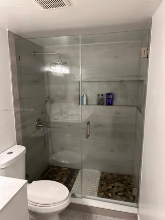 a bathroom with a toilet and a shower
