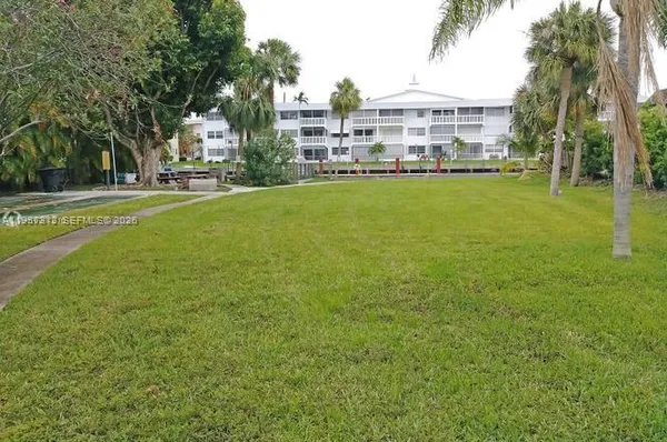 a view of a house with a big yard and large trees