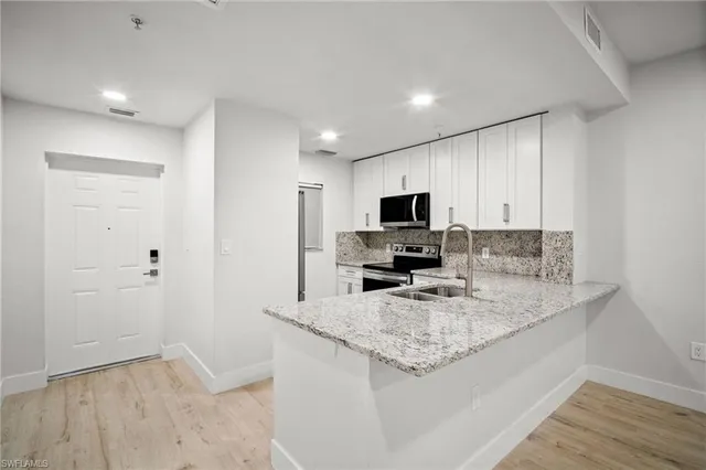 a kitchen with granite countertop a sink and a stove top oven