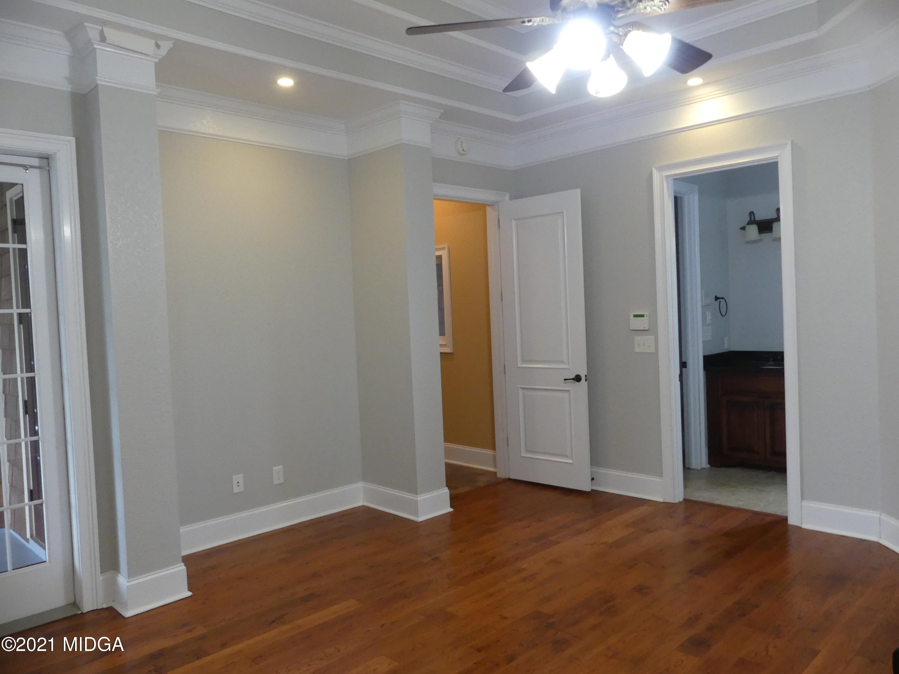 1616 Wadley Road Macon, GA 31220 - Photo 24 of 56 a view of an empty room with wooden floor and a ceiling fan