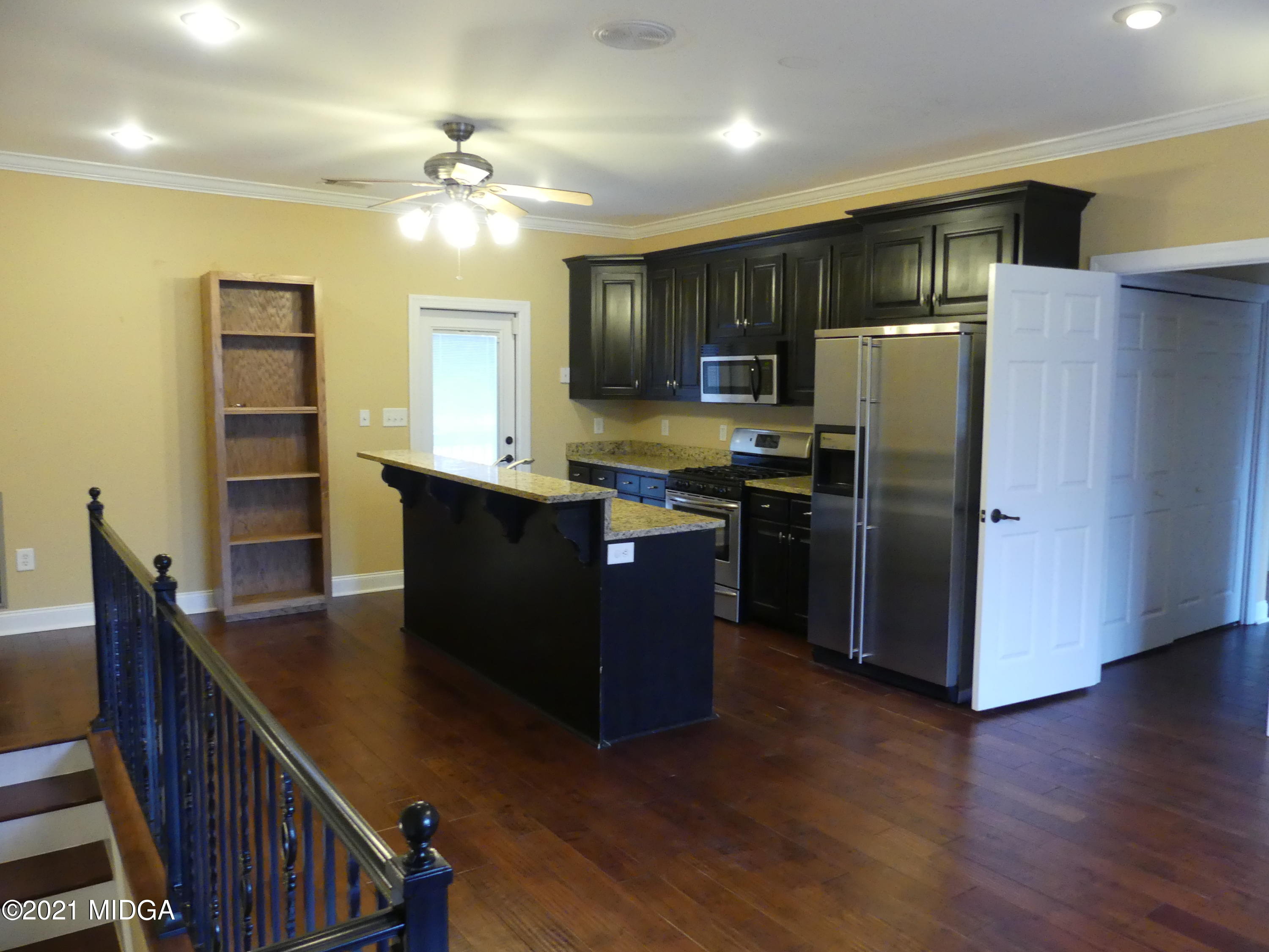 1616 Wadley Road Macon, GA 31220 - Photo 41 of 56 a kitchen with stainless steel appliances granite countertop a refrigerator a sink dishwasher a stove and a dining table with wooden floor