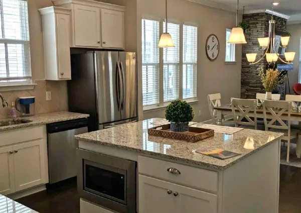 a kitchen with stainless steel appliances granite countertop a sink and a refrigerator