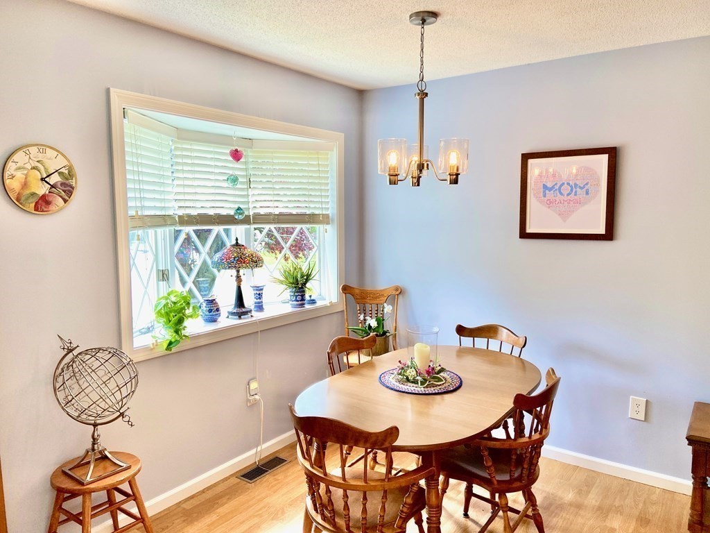 149 The Meadows, Unit 149 Enfield, CT 06082 - Photo 3 of 14 a view of a dining room with furniture window and wooden floor