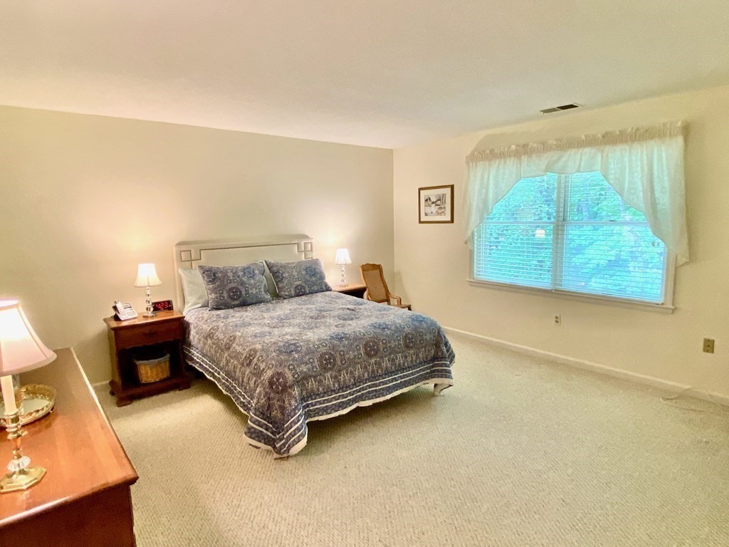149 The Meadows, Unit 149 Enfield, CT 06082 - Photo 8 of 14 a bedroom with a bed and a dresser