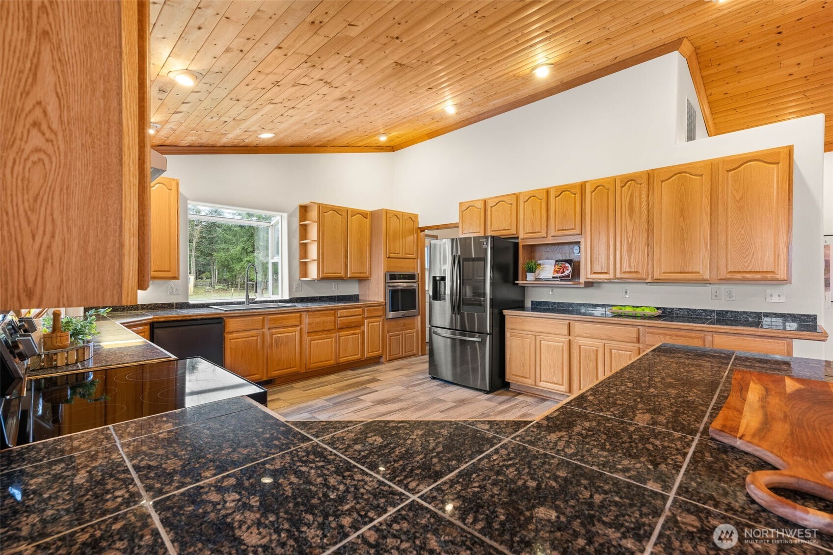 30608 40th Avenue South Roy, WA 98580 - Photo 12 of 40 a kitchen with stainless steel appliances kitchen island granite countertop a refrigerator and stove