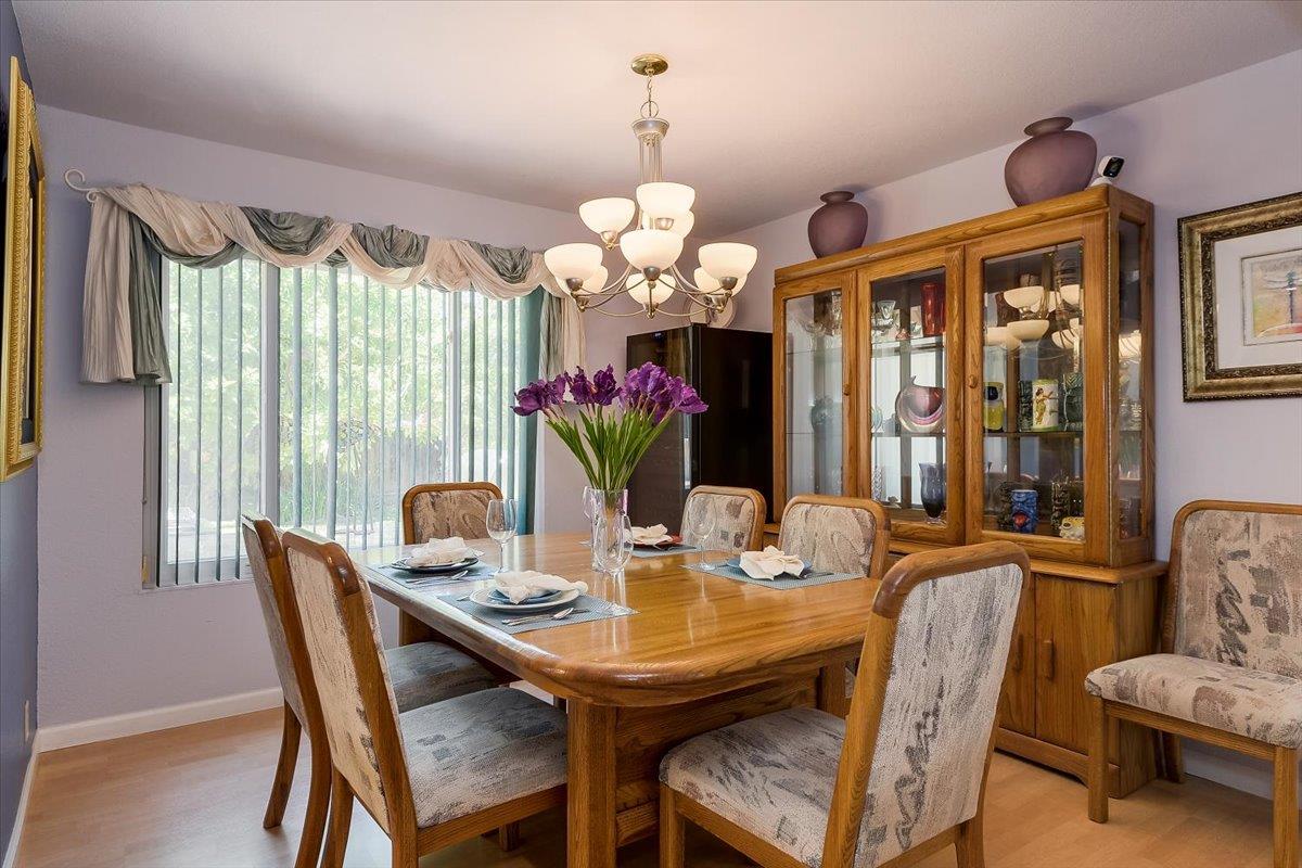1635 Serpa Drive Milpitas, CA 95035 - Photo 8 of 31 a dining room with wooden floor a chandelier a wooden table and chairs
