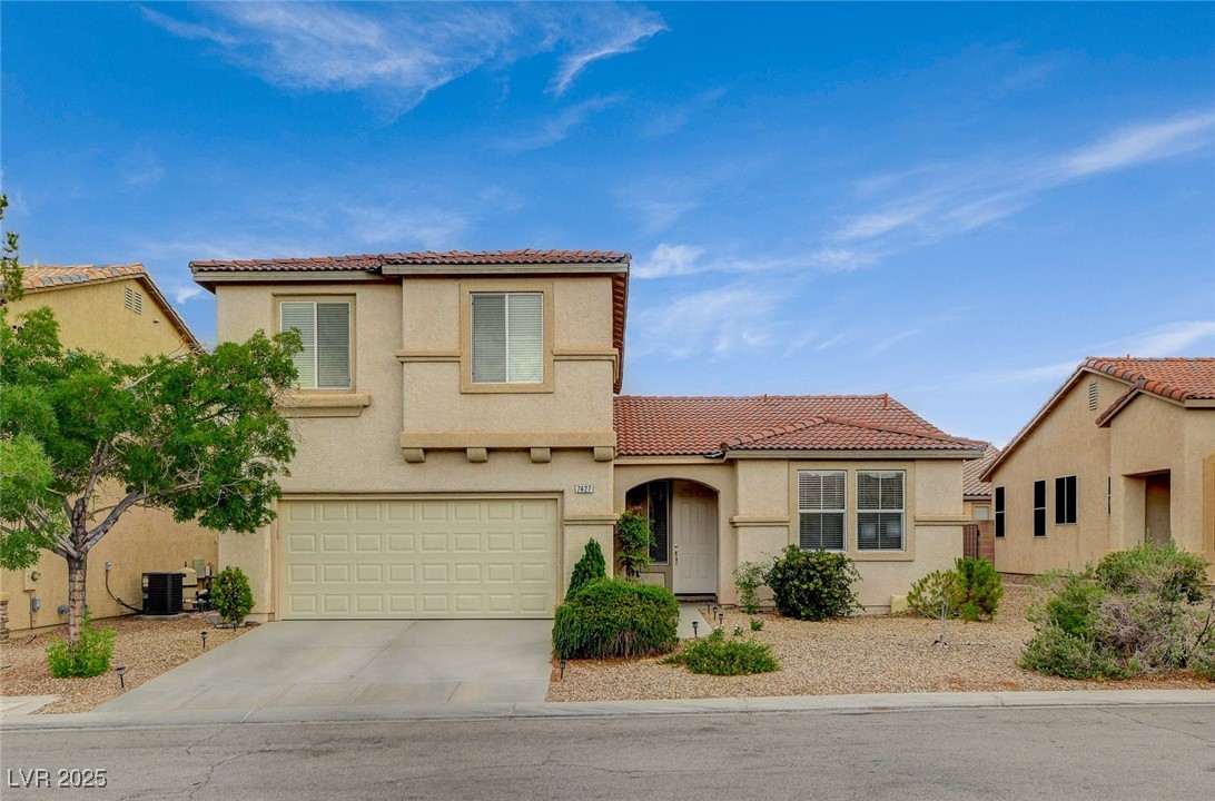 Mediterranean / spanish-style house featuring a tiled roof, driveway, stucco siding, and an attached garage