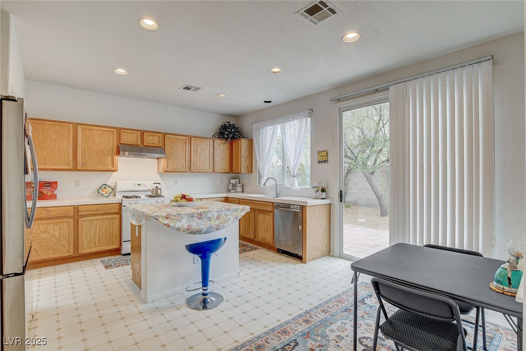 7427 Wagonwheel Ranch Way Las Vegas, NV 89113 - Photo 12 of 50 Kitchen with stainless steel appliances, under cabinet range hood, light countertops, a kitchen island, and recessed lighting