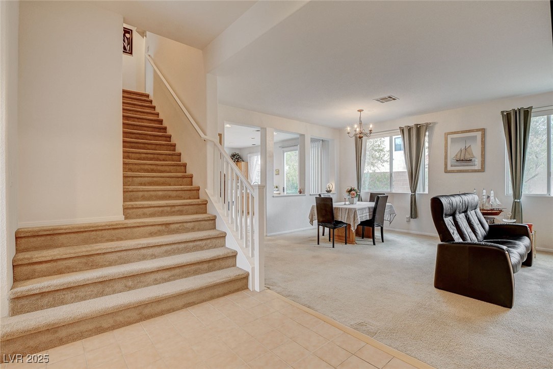 7427 Wagonwheel Ranch Way Las Vegas, NV 89113 - Photo 25 of 50 Carpeted dining space featuring stairs, a chandelier, and tile patterned flooring