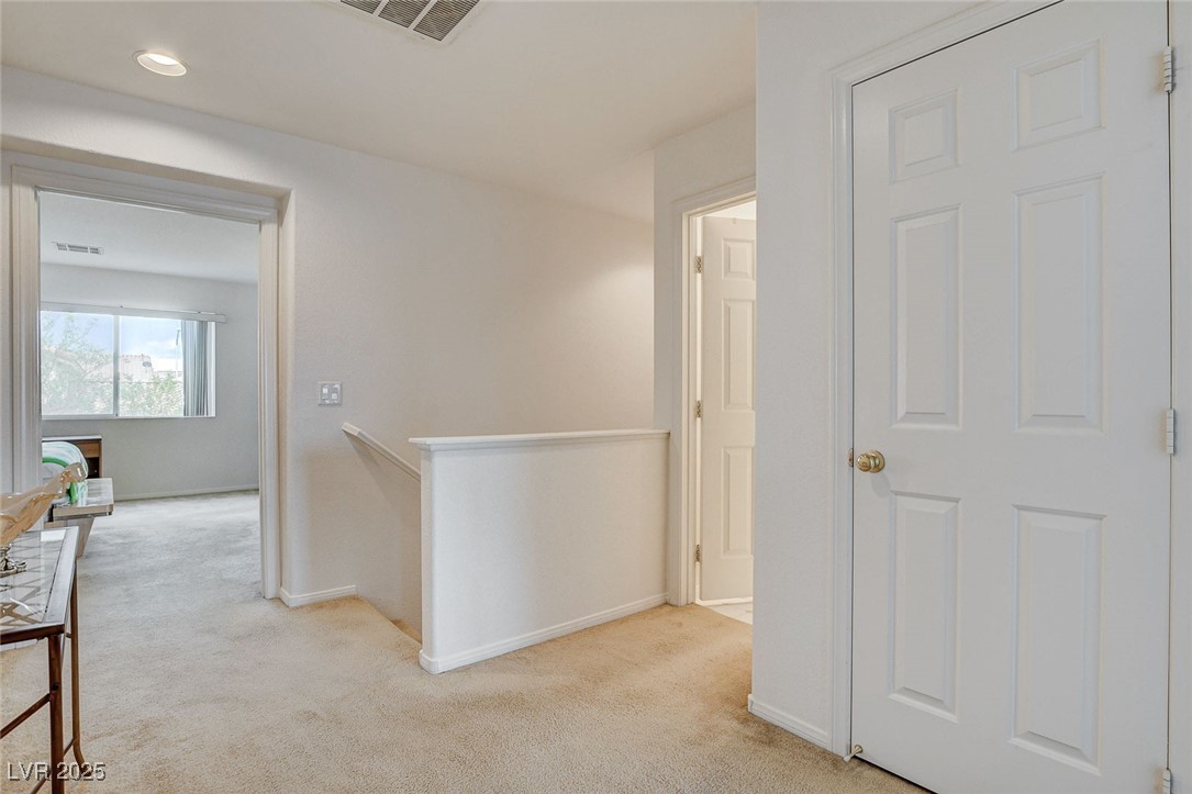 7427 Wagonwheel Ranch Way Las Vegas, NV 89113 - Photo 28 of 50 Hallway with light carpet and an upstairs landing