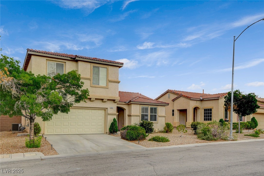 7427 Wagonwheel Ranch Way Las Vegas, NV 89113 - Photo 3 of 50 Mediterranean / spanish-style home featuring concrete driveway, stucco siding, a garage, and a tiled roof