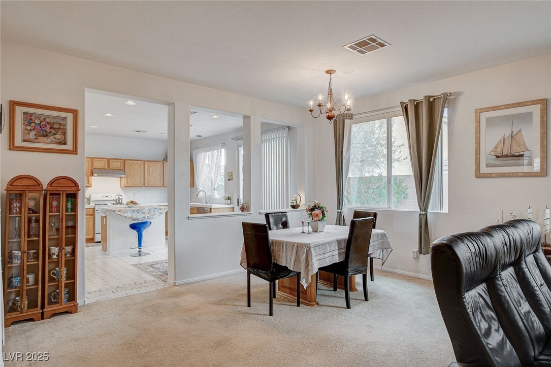 7427 Wagonwheel Ranch Way Las Vegas, NV 89113 - Photo 8 of 50 Dining room featuring a chandelier and light colored carpet