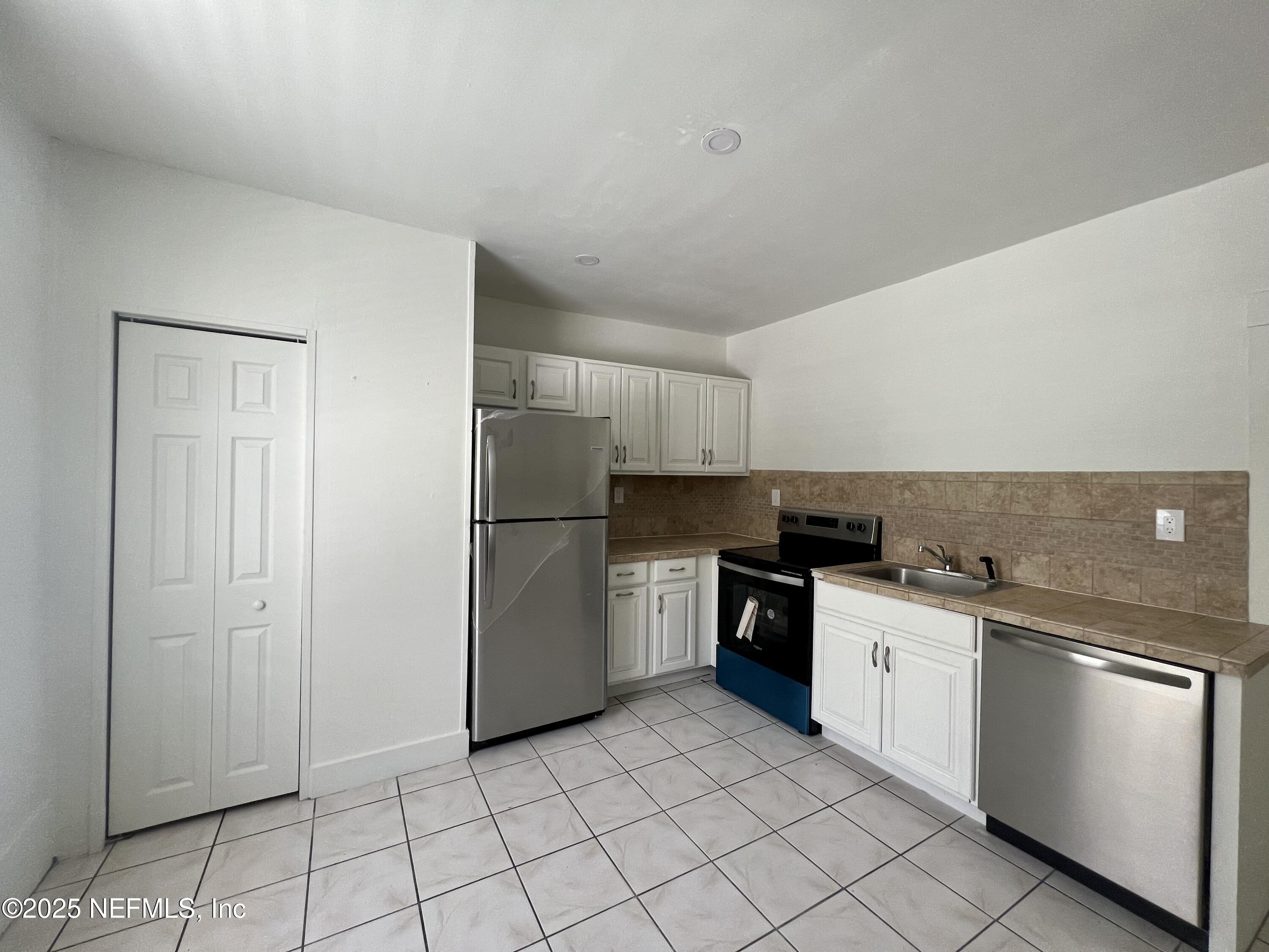 30 Sanford Street, Unit DOWN St. Augustine, FL 32084 - Photo 5 of 14 a kitchen with a stove top oven and cabinets