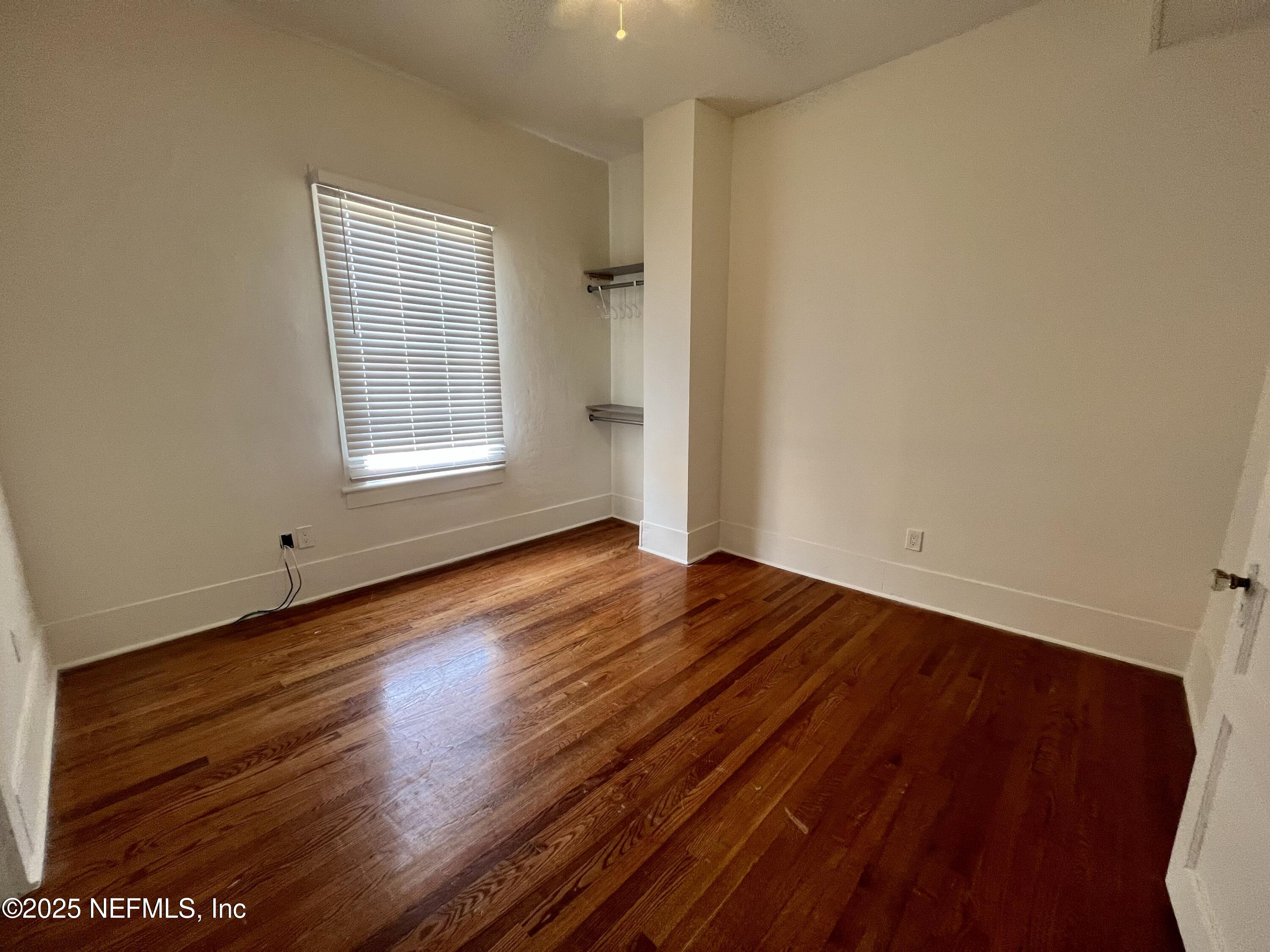 30 Sanford Street, Unit DOWN St. Augustine, FL 32084 - Photo 6 of 14 an empty room with wooden floor and windows