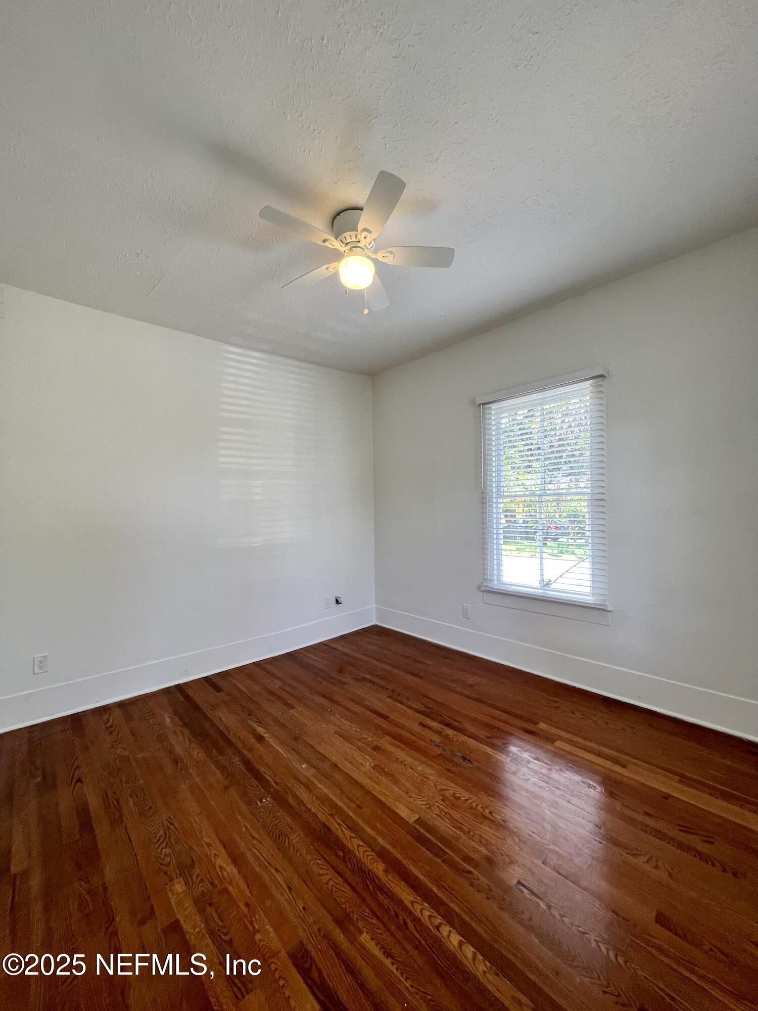 30 Sanford Street, Unit DOWN St. Augustine, FL 32084 - Photo 8 of 14 an empty room with wooden floor and windows