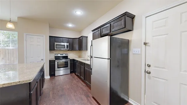 a kitchen with stainless steel appliances a refrigerator sink microwave and cabinets
