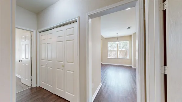 a view of a hallway with wooden floor and closet