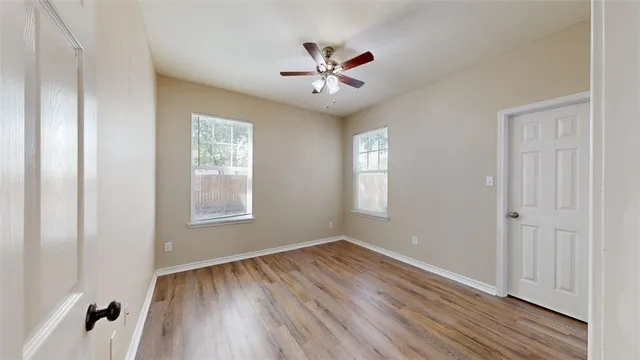 a view of a hallway with wooden floor and closet