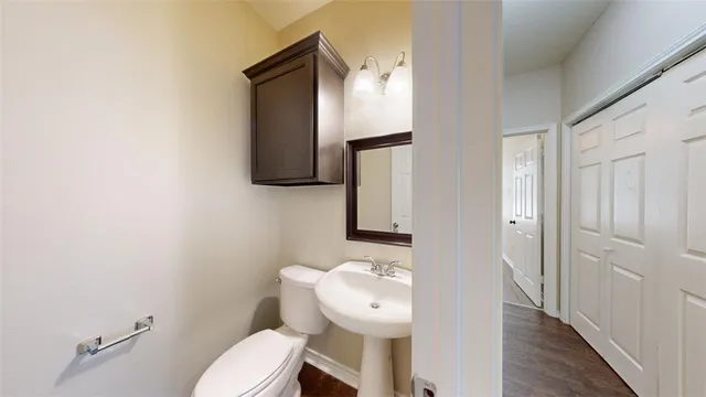 a bathroom with a granite countertop sink toilet and mirror